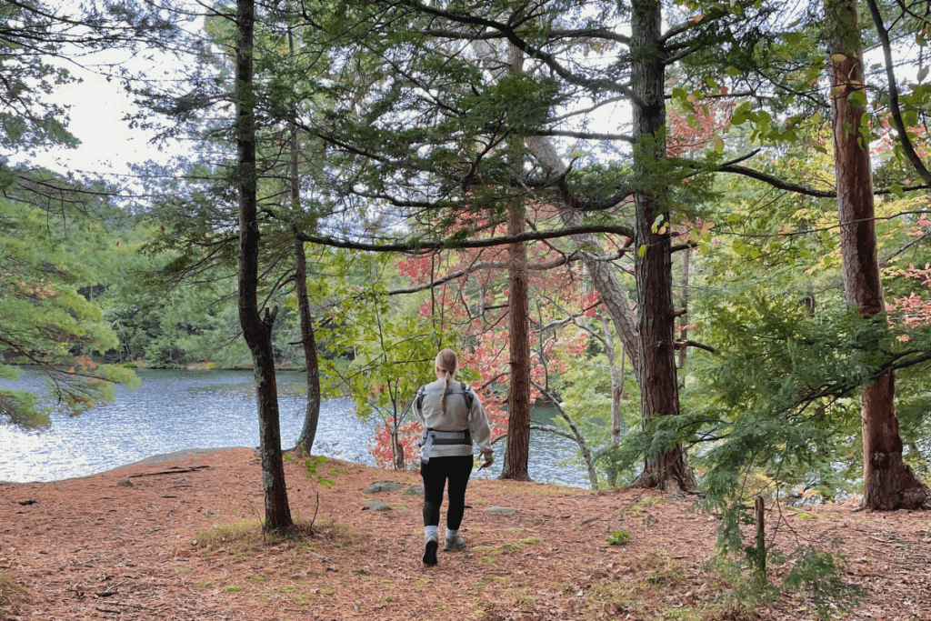 mother hiking with baby in upstate NY walking towards lake